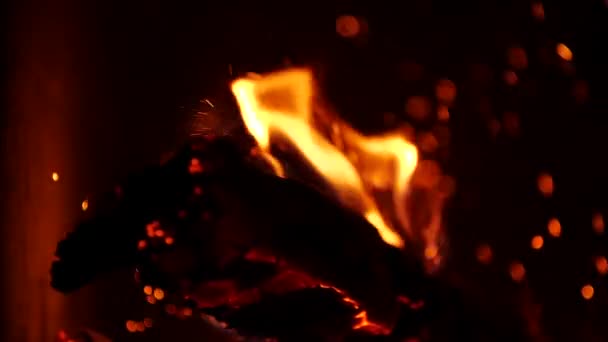 Mouvement lent de cheminée chaleureuse et confortable. Belles étincelles montantes chaudes. Ouvrez le feu. Gros plan de flammes sur fond noir .