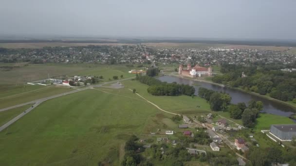 Πυροβολήθηκε από πάνω από το χωριό Μιρ και Μιρ Καστλ στη Λευκορωσία σε αργή κίνηση. Αρχαία υπερηφάνεια και θέαμα το φθινόπωρο από μια πανοραμική θέα. Πανόραμα μικρού χωριού και παλιού κτιρίου, θέα. — Αρχείο Βίντεο