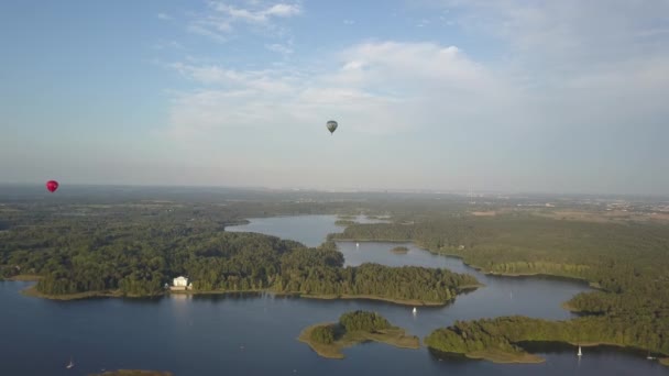 Dos globos aerostáticos sobre el castillo de Trakai, que se encuentra en Lituania, cerca de la capital de Vilna, ya que es uno de los principales atractivos. Castillo medieval de Trakai en la isla del lago Galve desde una altura . — Vídeos de Stock