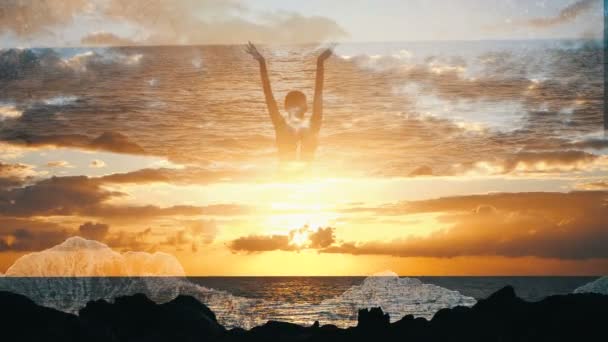 Silhueta de uma mulher no céu sobre o oceano levantando os braços ao pôr-do-sol. Menina observa ondas levantando-se no ar em câmera lenta e nuvens coloridas dramáticas. Superfície de água contra nuvens ao pôr do sol — Vídeo de Stock