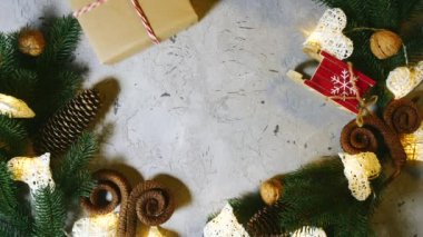 Oyuncak ve dekorasyonların arka planına karşı masaya kadın eli Noel hediyesi koyar, sonra da erkek eli alır. Aileyle Noel. Yeni yıl yakında. Yukarıdan görüntüle.