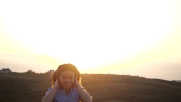 Ritratto ravvicinato di una ragazza femminile sorridente che corre e guarda alla telecamera nel paesaggio rurale. Attraente signorina sta agitando i capelli e girando verso la fotocamera. Bellezza naturale femminile al rallentatore . — Video Stock