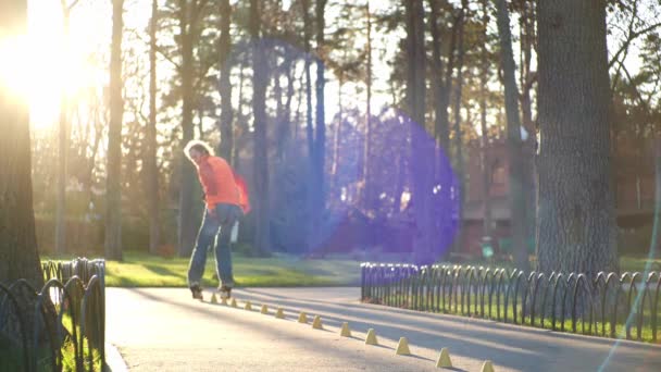 Technisches Rollschuhlaufen von einem erfahrenen professionellen Rollschuhfahrer in einem zentralen Stadtpark. gesunde und sportliche Freizeit nach der Arbeit. Ein männlicher Rollschuhfahrer vollführt komplexe Drehungen in Zeitlupe. — Stockvideo