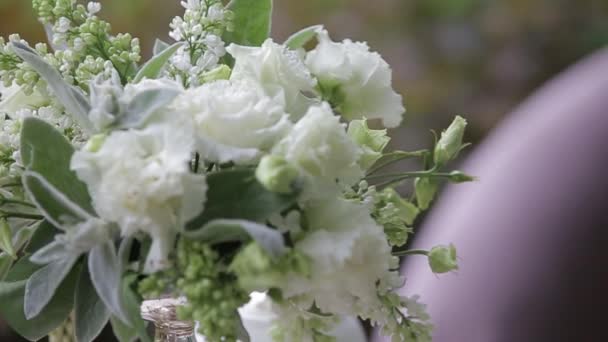 Hot tea in white cups served outdoors on a white table decorated with a bouquet of flowers. — Stock Video