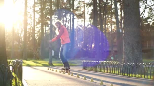 Cool roller entraîne sa technique de patinage à roulettes, roule vers l'arrière et croise les jambes et conduit entre les cônes. Entraînement en vue vers le bas d'un athlète barbu expérimenté par beau temps ensoleillé au ralenti . — Video