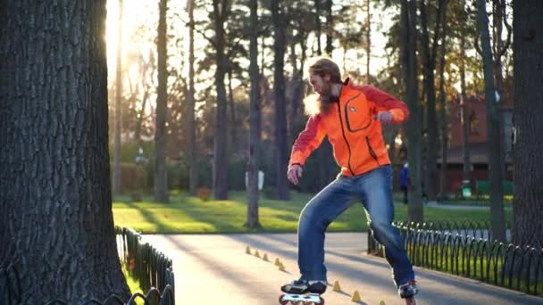 Mesmerizing rullskridskoåkning från en sportig man. En teknisk och erfaren rulle är otroligt rider bakåt på rullar, korsar benen mellan träningskoner. Aktivt liv i slow motion. — Stockvideo