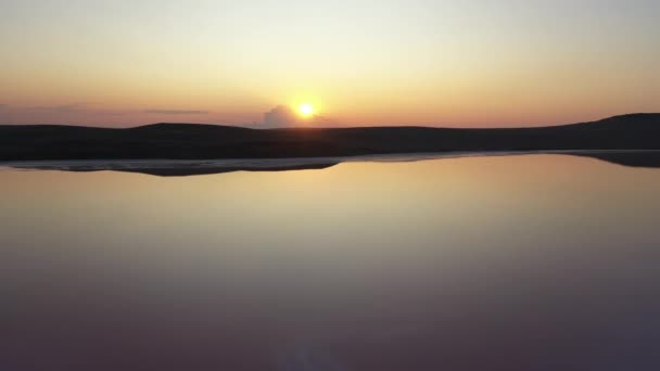 ドローンで上から撃墜された夜の有名な紅葉の湖。ウクライナのクリミア半島の夕日を背景に素晴らしい湖。スローモーションで塩、クリアとミネラルレイクトップビュー. — ストック動画