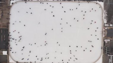 Kharkiv, Ukraine - January 2020: Large crowd of people skating on an outdoor ice rink on Freedom Square, in the center of Kharkov, Ukraine, aerial view. The concept of sports leisure and recreation.