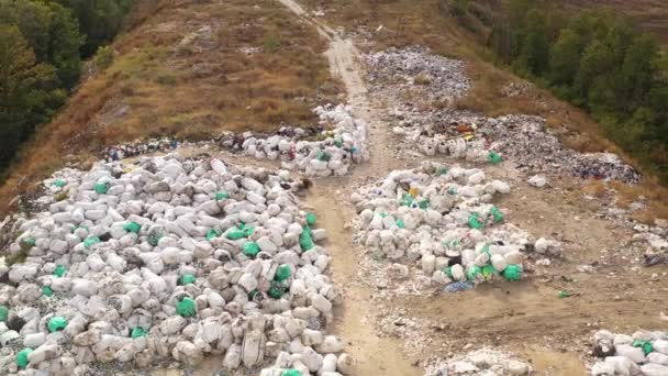 Luftaufnahme einer großen Mülldeponie in der Stadt Charkow, Ukraine. Riesige Müllberge und Müllsäcke liegen auf dem Boden und werden auf Deponien entsorgt. Blick von oben auf eine kontaminierte Oberfläche im Herbst. — Stockvideo