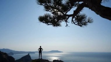 Genç atletik turist, Ukrayna 'nın Kırım, Karaul-Oba adlı dağının zirvesini fethetti. Işıl ışıl güneşli güzel bir deniz manzarası. Turizm, doğa keyfi ve temiz hava..