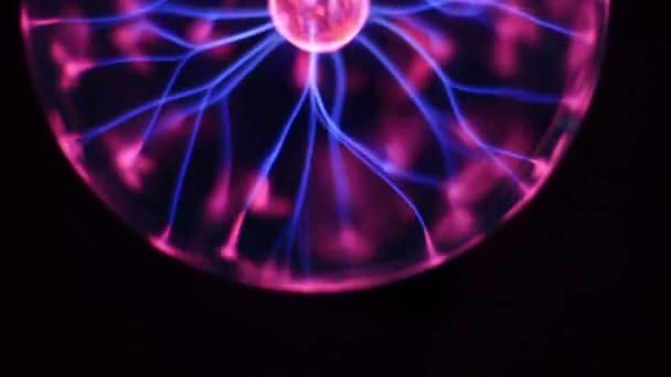 Движущаяся сфера плазменного шара молнии на черном фоне. Инертная газоразрядная трубка меняет цвет. Разрядная лампа Тесла, плазменный шар с высоковольтной молнией. Эксперимент с электричеством . — стоковое видео