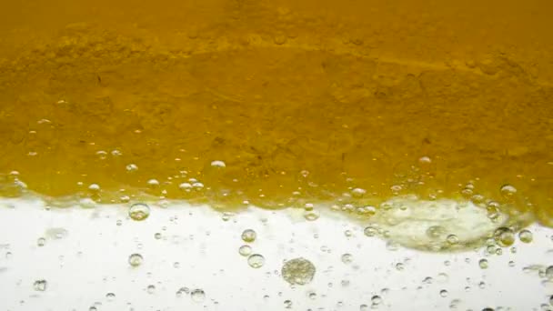 Vue rapprochée du mélange de tournage de graines de lin et d'huile de sésame sur fond blanc en laboratoire de recherche. Focus ébullition jaune huile d'arachide propagation largement bulle texture plein cadre et macro de nombreuses gouttelettes diverses .