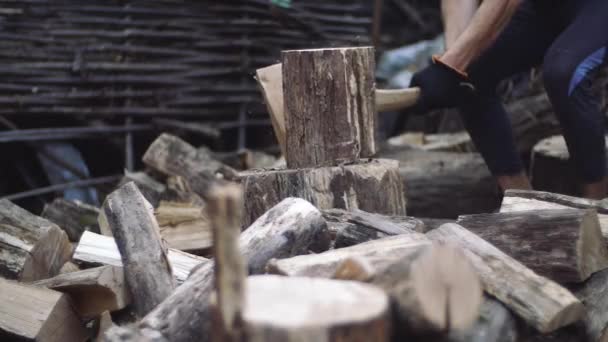 L'uomo taglia la legna all'aperto al rallentatore. Mans mani che lavorano con ascia. Un taglialegna uomo taglia tronchi d'albero con un'ascia per legna da ardere . — Video Stock