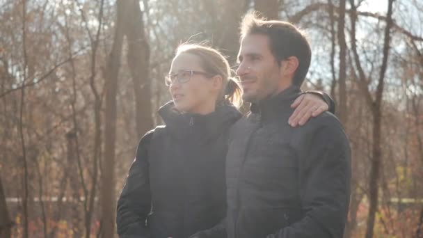 Jovem mãe e pai passam férias ativas em patins e com uma carruagem de bebê em um dia de folga. Tiro perto de pais de esportes andando ao longo do beco de um parque da cidade em patins de rolo em tempo ensolarado . — Vídeo de Stock