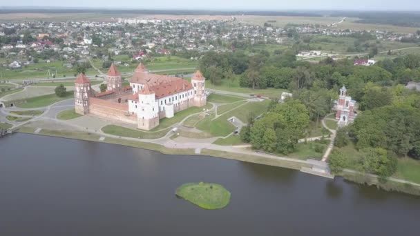 Vista superior del castillo de Mir es uno de los sitios culturales históricos más famosos de Bielorrusia. El castillo parece una verdadera fortaleza con cinco torres. Foto aérea del famoso edificio en el pueblo de Mir . — Vídeos de Stock