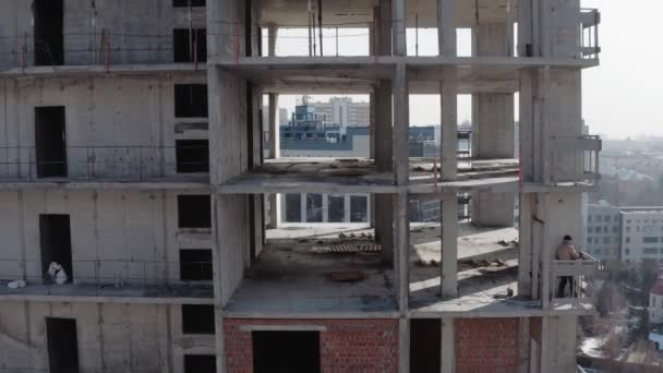 人々が住むための高層ビルと大規模な建物の建設。ウクライナのハリコフ市に建設中の新しい多階建ての建物。冬に住宅を建てる建築家. — ストック動画