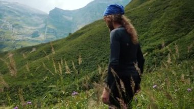 Erkek turist Kafkasya, Adygea, Rusya 'da yüksek bir dağda yürüyor. Dağı fetheden adamın arkası, temiz havanın tadını çıkarmaktan ellerini yana kaldırır..