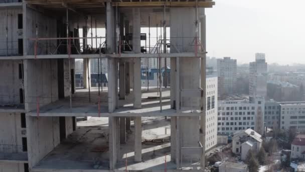 Upp-och-ner drönare fotografering av en oavslutad flervåningshus. Objekt under konstruktion, sidopanel vy. Byggande av en ny kontorsbyggnad i stadens centrum. Aktiv utveckling av staden. — Stockvideo