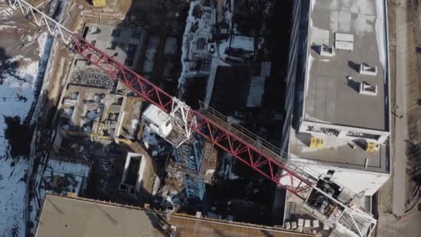 Vista superior de una grúa de construcción en un sitio de construcción en el centro de la ciudad de Jarkov, Ucrania. Construcción de nuevos edificios residenciales y de oficinas. Desarrollo de casas para vivir en invierno . — Vídeo de stock