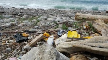 Ukrayna, Kırım 'daki Karadeniz kıyılarından birine kendiliğinden atık boşaltma. Çevre kirliliği ve dünya çapında bir felaket var. Sahilde deniz dalgaları yakınında çeşitli çöplerin yanında çekim yapıyorlar..