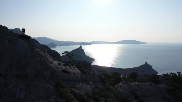 Bella alba sul Mar Nero e la montagna Karaul-Oba in Crimea. Le persone ispirate hanno raggiunto i loro obiettivi e sono salite sulla cima della montagna. Coppia sportiva conquistato la montagna . — Video Stock