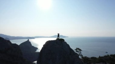 Birbirine aşık bir çiftin Karadeniz üzerinden dağın tepesine tırmanan görüntüsü. Bir çift turistten esinlenerek erkek ve kadın güneşin doğuşunda ve yüksek bir dağda sarılıp öpüşürler..
