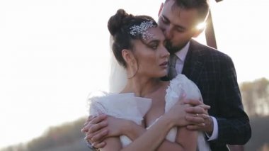 Sakallı damat sırtından sarılır ve sevgili gelinini ıssız bir tarlada güneşin altında öper. Düğün seremonisinden sonra çiftlerin doğası gereği sonbaharda yürüyün..