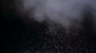 Boşlukta uçuşan karlı buhar ve siyah bir arkaplan. Issız bir yerde karlı sigara dumanı. Sisi olan bir kar fırtınası, zifiri karanlığın arka planına karşı havada süzülür..