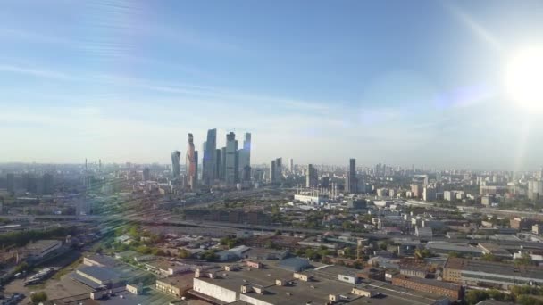 Drapacze chmur w Moskwie przez promienie słońca. Centrum biznesowe Moskwy. Wieże i domy stolicy Rosji z rozbłyskiem słonecznym. Widok z lotu ptaka, 4K. — Wideo stockowe