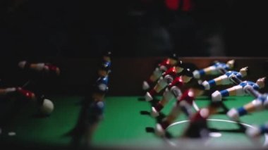 İnsanlar masa futbolu oynarlar, kendi elleriyle küçük futbolcuların oyuncaklarını tutacaklarından oynatırlar, oyuncak topa vururlar. Arkadaşlarla eğlence ve hobiler..