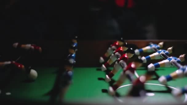 People play table football, with their own hands they move the toys of little football players by the handles, they kick the toy ball. Fun fun and hobbies with friends. — Stock Video