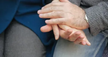 Güçlü yaşlı erkek ellerinin, saati kucaklayan ve kadın ellerini ütüleyen yakın plan görüntüsü. Yaşlı kocayı sevmek parkta otururken karısının ellerini okşar. Yaşlıların romantizmi.