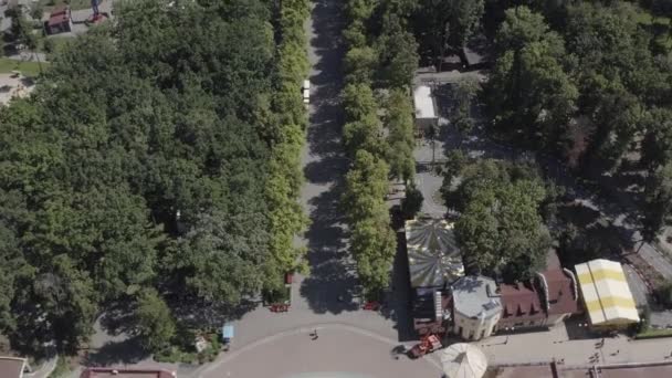 Vue aérienne de la ruelle vers l'avant entourée d'arbres de diverses attractions dans Gorky Park par une journée ensoleillée d'été dans le centre de Kharkov, en Ukraine. Parc d'attractions pour enfants et adultes, vue sur le dessus .