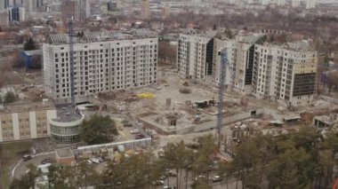 İnşaat alanının en üst görüntüsü, inşaat vinçlerinin çekilmesi ve yeni yüksek ofis binaları ve beyazlı konutlar inşa edilmesi Harkov şehir panoramasının arka planına karşı.