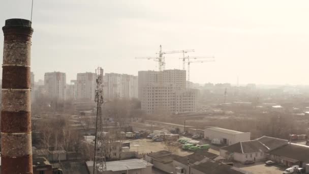 Approaching aerial shot of the city landscape and the construction of new buildings for office and housing and construction cranes in Kharkov, Ukraine. Industrial area of city from above. — Stock Video