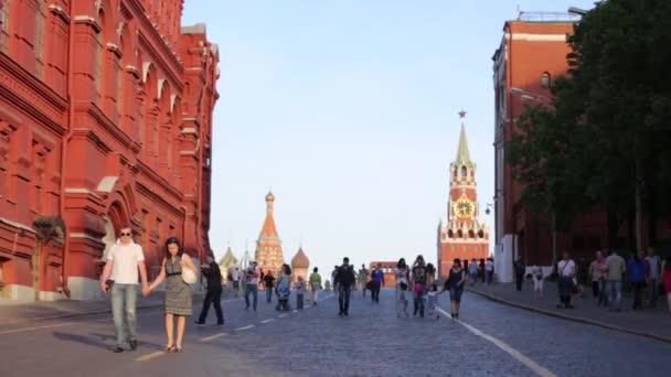 Rusya, Moskova - 06.05.2019: Güneşli bahar havasında Spasskaya Kulesi ve St. Basils Katedrali 'nin arka planına karşı Kızıl Meydan' da yürüyen kalabalık. Aktif eğlence dışarıda.. — Stok video