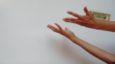 Güzel kadın elleri beyaz arka planda farklı avro ve dolar banknotları yakalamaya çalışır. Bir kadın para yakalamak için ellerini kaldırır tepeden tırnağa uçar ve 200 dolarlık banknotlar yakalar..