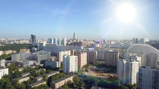 Muchos edificios de apartamentos de gran altura en el clima soleado de la mañana contra el horizonte con un cielo azul, vista superior. Moscú, Rusia. Vista superior del distrito de negocios bajo el sol brillante y el resplandor de la mañana . — Vídeo de stock