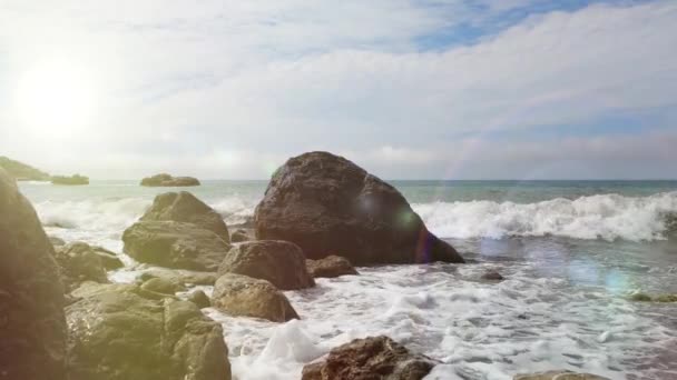 Maravilhosas ondas do mar Negro colidem com pedras em clima ensolarado, localizado ao largo da costa, Crimeia, Ucrânia. Um pequeno e belo respingo de água do mar sobre rochas e pedras em câmera lenta. Natureza acolhedora . — Vídeo de Stock