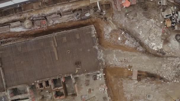 Flying over the construction site from a height where new modern residential building is being built. Process of building office multistory building in the City center, development. — Stock Video