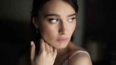 Kocaman gözleri, çıplak omuzları ve turkuaz iç çamaşırları olan üzgün, güzel güzel bir kız melankolik ve hoşnutsuz. Kadın, sabahları otel odasında zarif bir şekilde parmağını yüzüne doğru kaydırıyor.