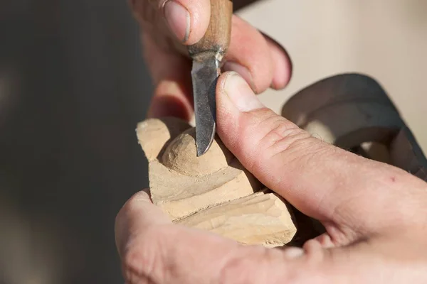 一个男人雕刻木材特写 只有手 工具和木片是可见的图片 — 图库照片