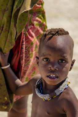 Opuwa, Bölge: Kunene, Namibia, 17 Ekim 2017: geleneksel iki örgülü hairplates ileri genişletilmiş gösterilen genç Himba kız