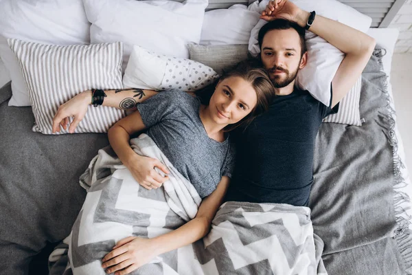 爱情故事夫妻俩早上躺在床上 抬头看着白色的枕头 丈夫和妻子家庭顶部视图 — 图库照片