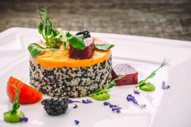 Susam ve havuç püresi, ıspanak ve domates, bir eski ahşap masa ve kare beyaz tabak kabak püresi. Yan görünüm, yakın çekim