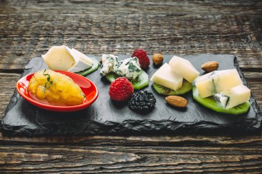 Peynir kurulu ile farklı tip-in peynir, kivi, ahududu, böğürtlen, badem ve ballı