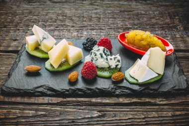 Peynir kurulu ile farklı tip-in peynir, kivi, ahududu, böğürtlen, badem ve ballı
