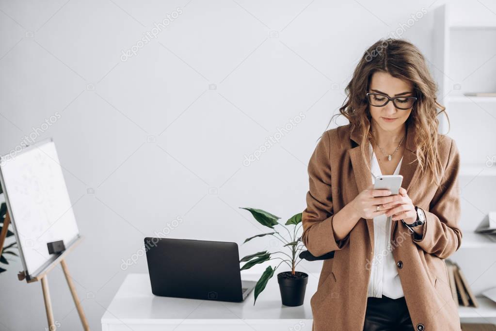Photo of a modern stylish girl which holding smartphone in her hands and look for  some information
