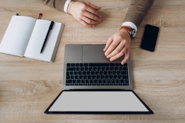 Male hands and laptop on the desk. Laptop with blank white screen and with space for text. Top view clipart