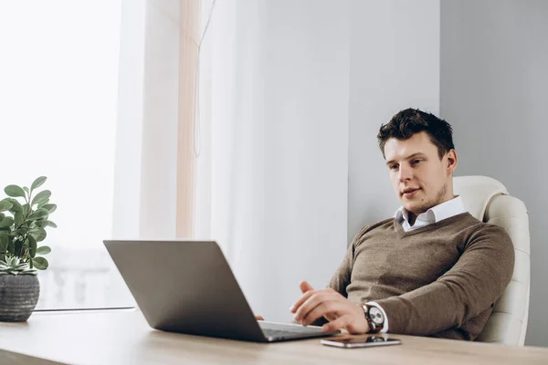 Atraktivní Chlapík Náramkové Hodinky Sedí Stolu Kanceláři Jeho Laptopu Dívá — Stock fotografie